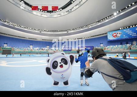 (221005) -- PEKING, 5. Oktober 2022 (Xinhua) -- Ein Tourist posiert für Fotos beim National Speed Skating Oval in Peking, der Hauptstadt Chinas, 9. Juli 2022. Laut der National Cultural Heritage Administration haben die chinesischen Behörden geplant, die Pekinger Zentralachse als Chinas Bewerbungsprojekt für das Weltkulturerbe im Jahr 2024 zu empfehlen.die Pekinger Zentralachse ist 7,8 Kilometer lang, Ausgehend vom Yongding Gate im Süden der Stadt und endend mit dem Drum Tower und dem Glockenturm im Norden. Die meisten der großen Altstadtgebäude von Peking befinden sich entlang dieser Achse. Die Mittelachse ist Th Stockfoto