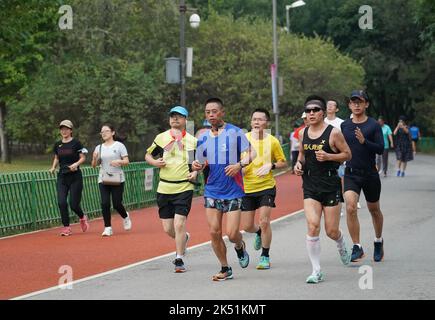 (221005) -- PEKING, 5. Oktober 2022 (Xinhua) -- Menschen laufen im Olympischen Waldpark in Peking, der Hauptstadt Chinas, am 11. September 2022. Laut der National Cultural Heritage Administration haben die chinesischen Behörden geplant, die Pekinger Zentralachse als Chinas Bewerbungsprojekt für das Weltkulturerbe im Jahr 2024 zu empfehlen.die Pekinger Zentralachse ist 7,8 Kilometer lang, Ausgehend vom Yongding Gate im Süden der Stadt und endend mit dem Drum Tower und dem Glockenturm im Norden. Die meisten der großen Altstadtgebäude von Peking befinden sich entlang dieser Achse. Die Mittelachse ist das Rückgrat des alten Beiji Stockfoto