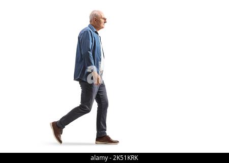 Ganzkörperaufnahme eines reifen Mannes in einem Jeanshemd, der isoliert auf weißem Hintergrund läuft Stockfoto