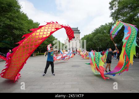 (221005) -- PEKING, 5. Oktober 2022 (Xinhua) -- Bürger üben auf dem Platz der Glockentürme in Peking, der Hauptstadt Chinas, am 29. August 2022. Laut der National Cultural Heritage Administration haben die chinesischen Behörden geplant, die Pekinger Zentralachse als Chinas Bewerbungsprojekt für das Weltkulturerbe im Jahr 2024 zu empfehlen.die Pekinger Zentralachse ist 7,8 Kilometer lang, Ausgehend vom Yongding Gate im Süden der Stadt und endend mit dem Drum Tower und dem Glockenturm im Norden. Die meisten der großen Altstadtgebäude von Peking befinden sich entlang dieser Achse. Die Mittelachse ist die Stockfoto