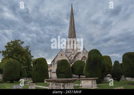Der Kirchhof in der St. Mary's Church in Painswick, Gloucestershire, ist berühmt für seine Eibenbäume Stockfoto