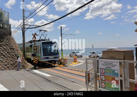 Der Zug der Enoshima Electric Railway passiert den Bahnübergang, wo eine berühmte Attraktion für Slam Dunk Fans in der Nähe der Kamakurakokomae Station ist Stockfoto