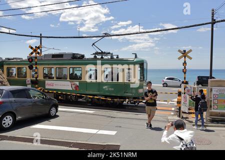 Der Zug der Enoshima Electric Railway passiert den Bahnübergang, wo eine berühmte Attraktion für Slam Dunk Fans in der Nähe der Kamakurakokomae Station ist Stockfoto