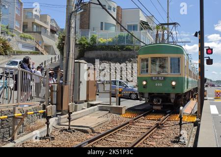 Der Zug der Enoshima Electric Railway passiert den Bahnübergang, wo eine berühmte Attraktion für Slam Dunk Fans in der Nähe der Kamakurakokomae Station ist Stockfoto