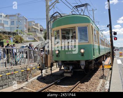 Der Zug der Enoshima Electric Railway passiert den Bahnübergang, wo eine berühmte Attraktion für Slam Dunk Fans in der Nähe der Kamakurakokomae Station ist Stockfoto