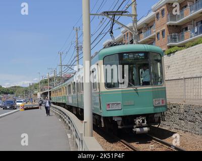 Der Zug der Enoshima Electric Railway passiert den Bahnübergang, wo eine berühmte Attraktion für Slam Dunk Fans in der Nähe der Kamakurakokomae Station ist Stockfoto