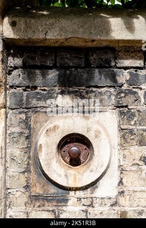 Die alte Türklingel zieht an der Wand des Sidney Sussex College in Cambridge, Großbritannien. Stockfoto