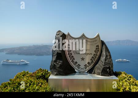 Fira, Santorini - September 4, 2022 :das Label eines berühmten Champagner, ein Kreuzfahrt-Schiff und der Vulkan von Santorini Griechenland Stockfoto