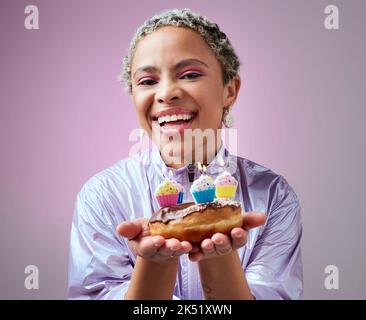 Geburtstagskuchen, Party und eine schwarze Frau auf rosa Hintergrund. Glückliches Mädchen, Geburtstagsfeier und Kuchen in den Händen. Cupcake Kerze, feiern und Mädchen mit Stockfoto