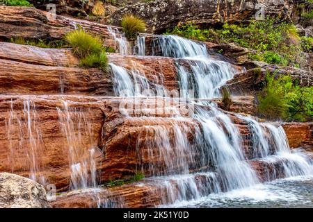 Das Wasser verschwimmt auf einem schönen kleinen Wasserfall zwischen den Felsen und der Vegetation des Biribiri-Naturschutzgebietes in Diamantina, Minas Gerais. Stockfoto