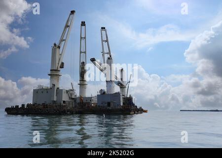 Schiffskräne werden zum Be- und Entladen von Fracht auf Schiffe, das Transport- und Distributionszentrum von Koh Sichang in Thailand, eingesetzt. Stockfoto