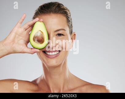 Avocado-Hautpflege, Frauenschönheit und Naturkosmetik für Gesichtsmaske, gesunde Ernährung und glückliche Ergebnisse auf grauem Studiohintergrund. Porträt von reifen Stockfoto