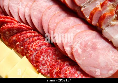 Unschärfe-Effekte von Wurst und Käse. Antipasto Catering-Platte mit Speck, Ruck, Salami, Käse Nahaufnahme Hintergrund. Nicht fokussiert. Stockfoto