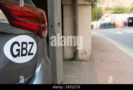 GBZ-Aufkleber auf der Rückseite des Fahrzeugs, das in der Auffahrt des Gebäudes geparkt ist. Die Buchstaben stehen für den internationalen Fahrzeugregistrierungscode für Gibraltar. Stockfoto