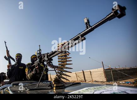 Gaza, Palästina. 04. Oktober 2022. Bewaffnete maskierte Kämpfer der Al-Quds Brigaden, des militärischen Flügels des Islamischen Jihad, während einer Kundgebung anlässlich des 35.. Jahrestages der Gründung der Bewegung in Khan Yunis im südlichen Gazastreifen. Kredit: SOPA Images Limited/Alamy Live Nachrichten Stockfoto