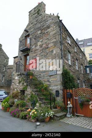 Ein altes Steinhaus am Ufer von Port St Mary, Isle of man. Ein schöner Steingarten schmückt die Steintreppen draußen. Stockfoto