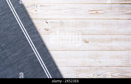 Glatte blaue Tischdecke, Serviette, raue Stofftextur auf Holzschreibtisch. Draufsicht. Stockfoto