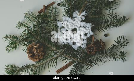 Makramé Schneeflocke Weihnachten Feiertagsdekoration auf Ästen mit Makrame handgefertigten Knot-Technik Stockfoto