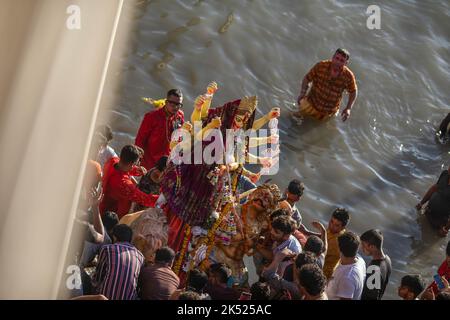 Dhaka, Bangladesch. 05. Oktober 2022. Hinduistische Anhänger tauchen am letzten Tag des Durga Puja-Festivals ein Idol der Hindu-Göttin Durga auf dem Buriganga-Fluss ein. Das viertägige Durga-Festival wird in ganz Bangladesch gefeiert und gipfelt im Eintauchen der Idole der Hindu-Göttin Durga, um die Macht und den Triumph des Guten über das Böse in der hinduistischen Mythologie zu symbolisieren. (Foto: Sazzad Hossain/SOPA Images/Sipa USA) Quelle: SIPA USA/Alamy Live News Stockfoto