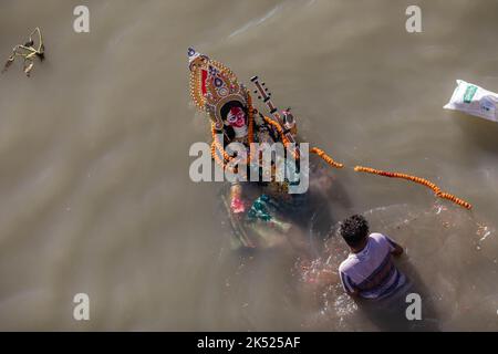 Dhaka, Bangladesch. 05. Oktober 2022. Hinduistische Anhänger tauchen am letzten Tag des Durga Puja-Festivals ein Idol der Hindu-Göttin Durga auf dem Buriganga-Fluss ein. Das viertägige Durga-Festival wird in ganz Bangladesch gefeiert und gipfelt im Eintauchen der Idole der Hindu-Göttin Durga, um die Macht und den Triumph des Guten über das Böse in der hinduistischen Mythologie zu symbolisieren. (Foto: Sazzad Hossain/SOPA Images/Sipa USA) Quelle: SIPA USA/Alamy Live News Stockfoto