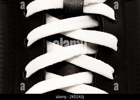 Hintergrund der weißen Schnürsenkel auf schwarzen Schuhen Nahaufnahme. Schnürsenkel Stockfoto