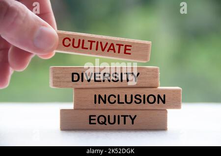 Hand halten Holzblock mit Text - kultivieren Vielfalt, Integration und Gerechtigkeit. Konzept der Unternehmenskultur. Stockfoto