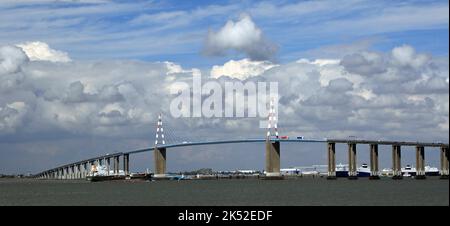 Ein Frachtschiff fährt unter der Saint Nazaire-Brücke an der Loire, Frankreich, vorbei Stockfoto