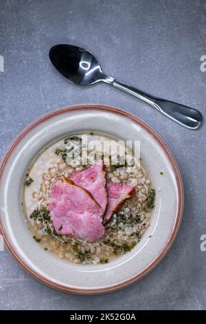 Brühe mit geräuchertem Fleisch und Grütze Stockfoto