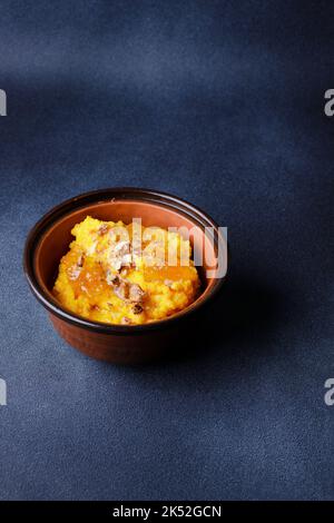 Süßer Kürbisbrei in Tonschüssel mit Marmelade und Nüssen Stockfoto