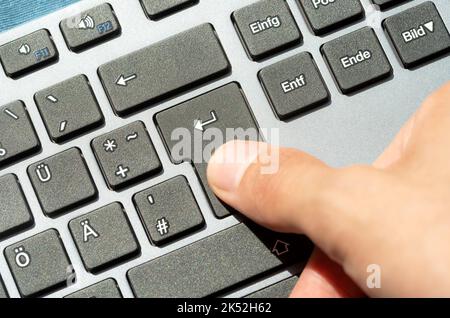 Mann, der die ENTER-Taste auf einer modernen Computertastatur drückt, Draufsicht, Handfingerdetail, Nahaufnahme akzeptieren, bestätigen, Kauf, Senden einer Online-m Stockfoto