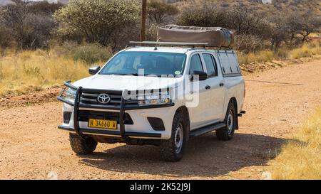 Windhoek, Namibia - 28. September 2018: Typischer 4x4 Mietwagen in Namibia mit Campingausrüstung und einem Dachzelt, das auf einer unbefestigten Straße durch das Land fährt Stockfoto