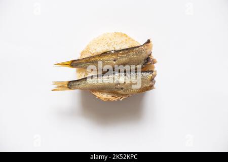 Sprotte auf einem Stück Weißbrot, Sandwich mit Fisch auf einem isolierten Hintergrund Stockfoto