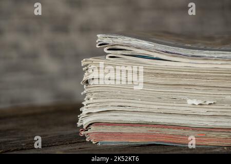 Auf dem Tisch liegt ein Stapel von Zeitschriften und Zeitungen, eine Tageszeitung Stockfoto