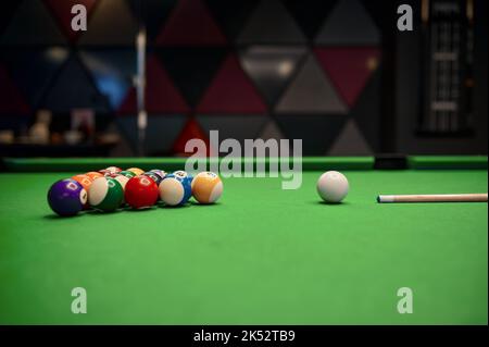 Billardtisch mit Kugeln und Queue Stockfoto