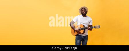 In voller Länge Foto von Angeregten künstlerische Mann, der seine Gitarre spielen. Auf gelben Hintergrund. Stockfoto