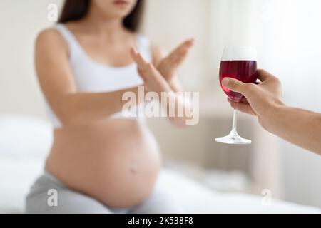 Nicht erkennbare Schwangerin weigert sich, Wein zu trinken, abgeschnitten Stockfoto