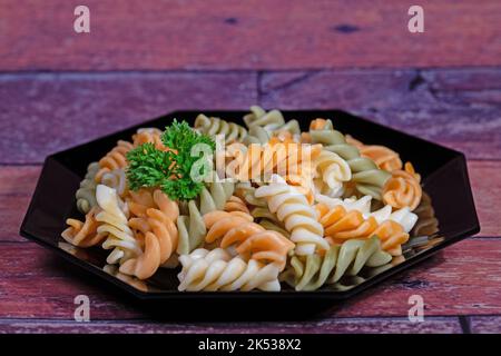 Bunte Spiralnudeln auf einem Teller Stockfoto