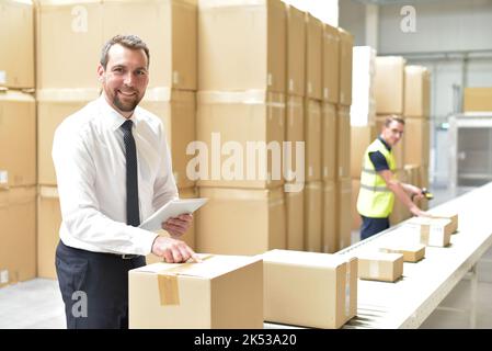 Workerand Manager in einem Lager in der Logistik-Branche - Transport und Bearbeitung von Aufträgen im Handel Stockfoto