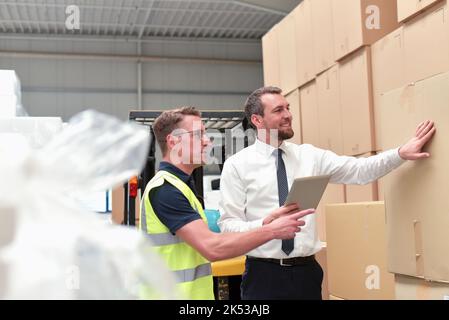 Workerand Manager in einem Lager in der Logistik-Branche - Transport und Bearbeitung von Aufträgen im Handel Stockfoto