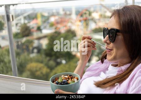 Junge Frau, die Chia-Pudding mit Nüssen und Beeren isst Stockfoto