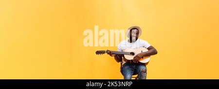 In voller Länge Foto von Angeregten künstlerische Mann, der seine Gitarre spielen. Auf gelben Hintergrund. Stockfoto