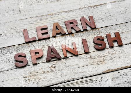 Text SPANISCH LERNEN auf weißem Holzhintergrund Stockfoto