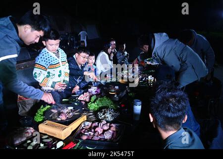 QINGDAO, CHINA - 5. OKTOBER 2022 - Besucher haben ein Camping-Abendessen auf einem Campingplatz in Qingdao, Provinz Shandong, China, 5. Oktober 2022. Stockfoto