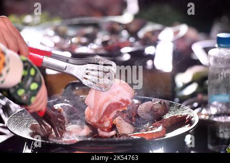 QINGDAO, CHINA - 5. OKTOBER 2022 - Besucher braten Fleisch bei einem Picknick auf einem Campingplatz in Qingdao, Provinz Shandong, China, 5. Oktober 2022. Stockfoto