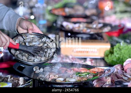 QINGDAO, CHINA - 5. OKTOBER 2022 - Besucher braten gegrillte Meeresfrüchte auf einem Campingplatz in Qingdao, Provinz Shandong, China, 5. Oktober 2022. Stockfoto