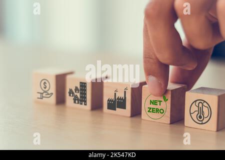 Nettoziel Null und CO2-neutral. Umweltfreundliches Geschäftskonzept. Probleme mit dem Klimawandel, Ziele zu lösen. Setzen Holzwürfel mit Netz Null-Symbol und Pollu Stockfoto