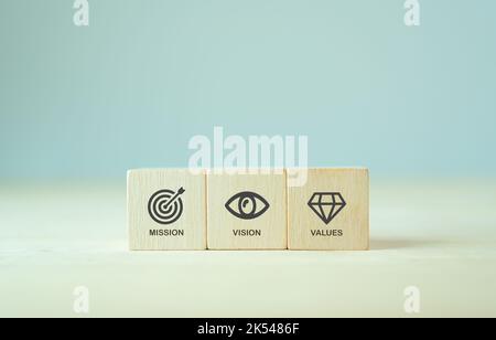 Mission, Vision und Werte des Unternehmens. Zweck Geschäftskonzept. Die Holzwürfel mit Mission, Vision und Werte Symbole auf grauem Hintergrund, kopieren Spa Stockfoto