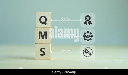 QMS, Qualitätsmanagementsystemkonzept. Formalisiertes System zur Erreichung von Qualitätspolitiken und -Zielen. ISO 9001-Standard. Holzwürfel mit Abbrev Stockfoto