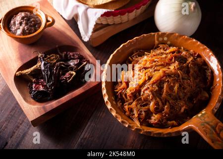 Tinga de Res. Typisch mexikanisches Gericht, das hauptsächlich mit geschreddertem Rindfleisch, Zwiebeln und getrockneten Chilischoten zubereitet wird. Es ist üblich, es auf Maistortilla Tostadas zu servieren Stockfoto