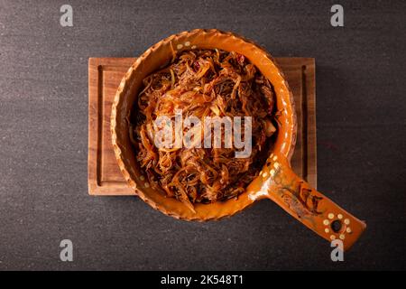 Tinga de Res. Typisch mexikanisches Gericht, das hauptsächlich mit geschreddertem Rindfleisch, Zwiebeln und getrockneten Chilischoten zubereitet wird. Es ist üblich, es auf Maistortilla Tostadas zu servieren Stockfoto